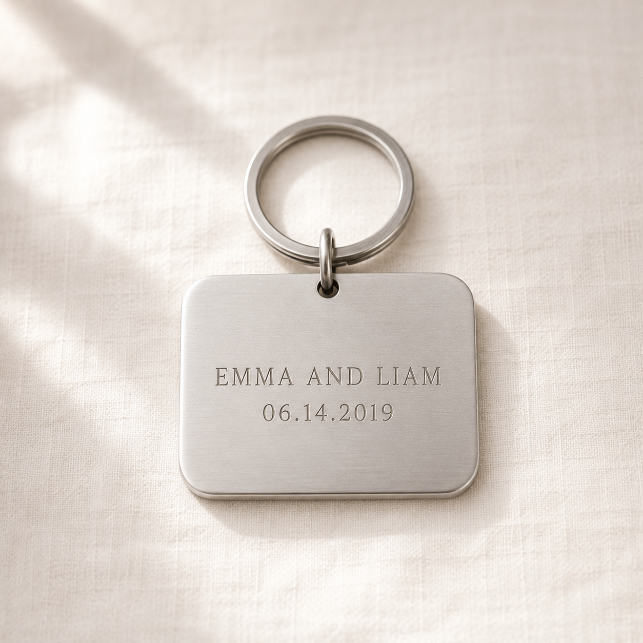 Stainless steel keychain engraved EMMA AND LIAM with a date