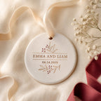 A ceramic couple ornament on cream linen with a cotton ribbon, dried flowers and a plum ribbon