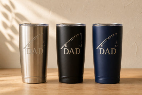 Three engraved tumblers side by side in stainless, matte black and navy, each marked DAD with a fishing rod motif
