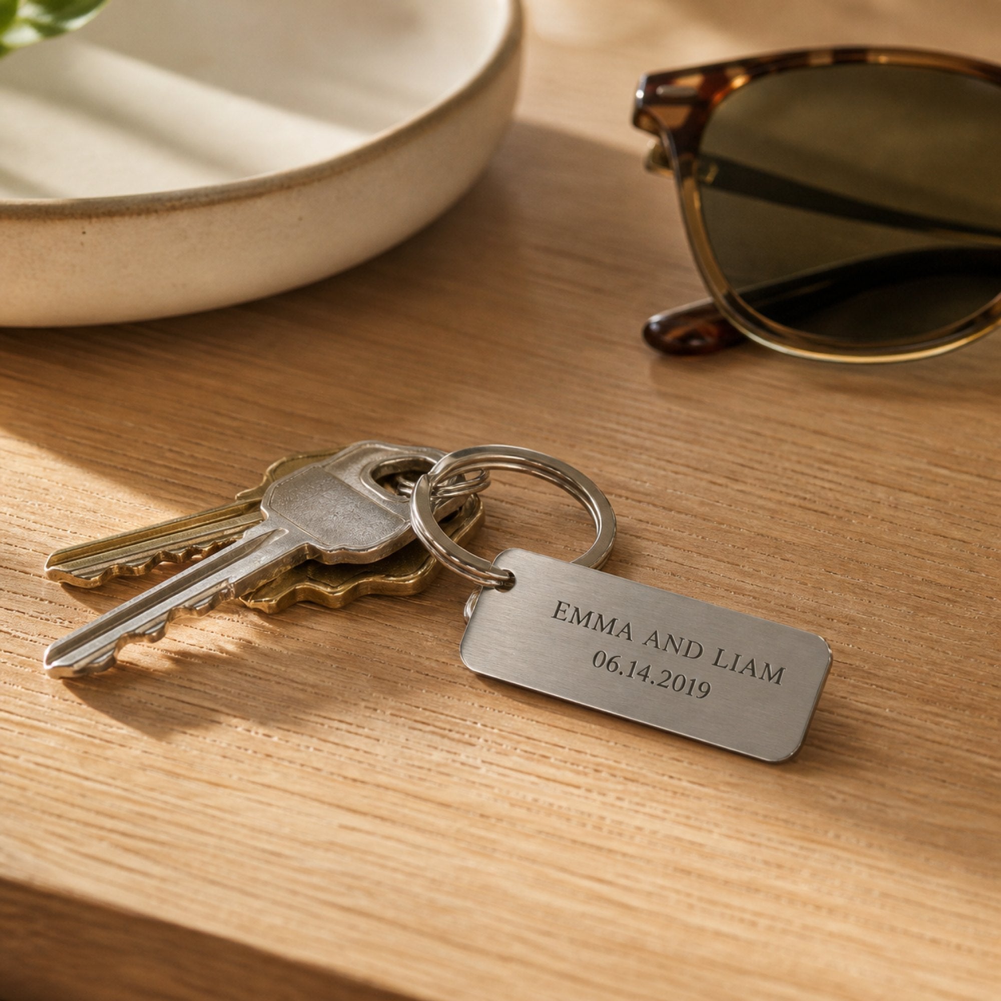 An engraved keychain on a set of house keys resting on an oak entryway table