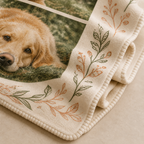 Close-up of ivory personalized photo blanket showing golden retriever print, botanical border, fleece texture and stitched edge