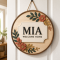 Personalized round birch wood name sign with layered botanical details and sample name MIA