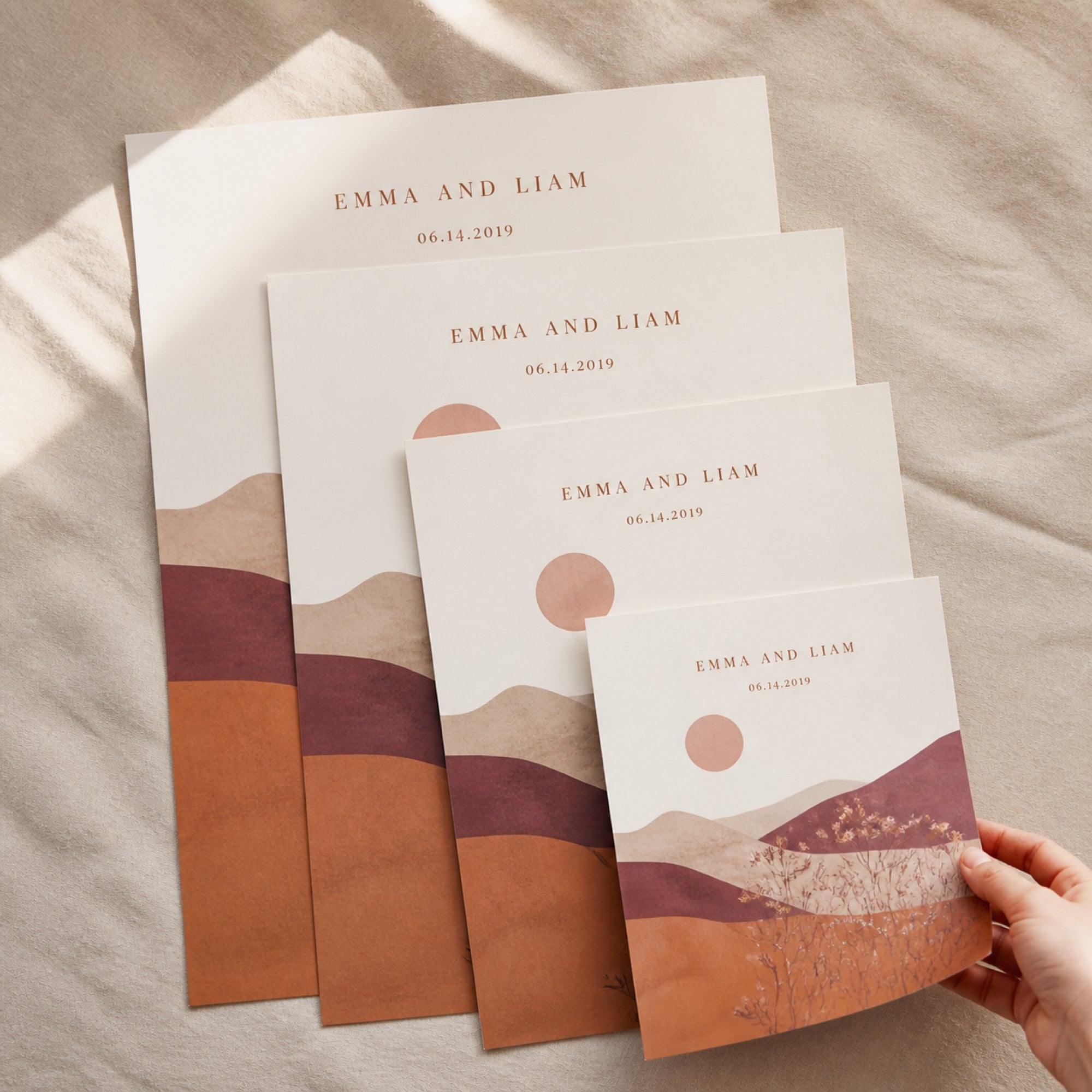 Four unframed prints of different sizes fanned out on cream linen to compare the scale