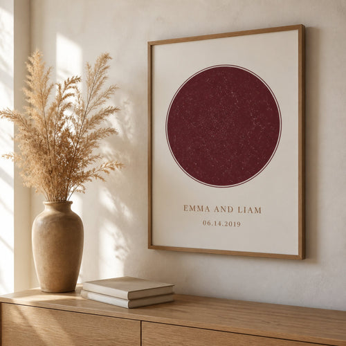 A framed anniversary print hanging above an oak sideboard, showing the size of the frame in a room