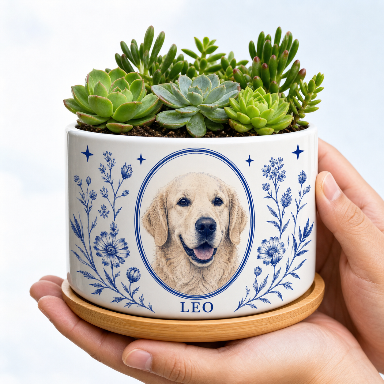 White ceramic personalized pet portrait planter with cobalt botanical artwork, golden retriever portrait, sample name LEO and green succulents