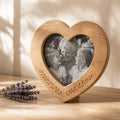 Personalized wooden heart photo frame with a family portrait in warm natural light