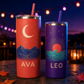 Two personalized insulated tumblers with moon and sunrise artwork in a colorful evening setting